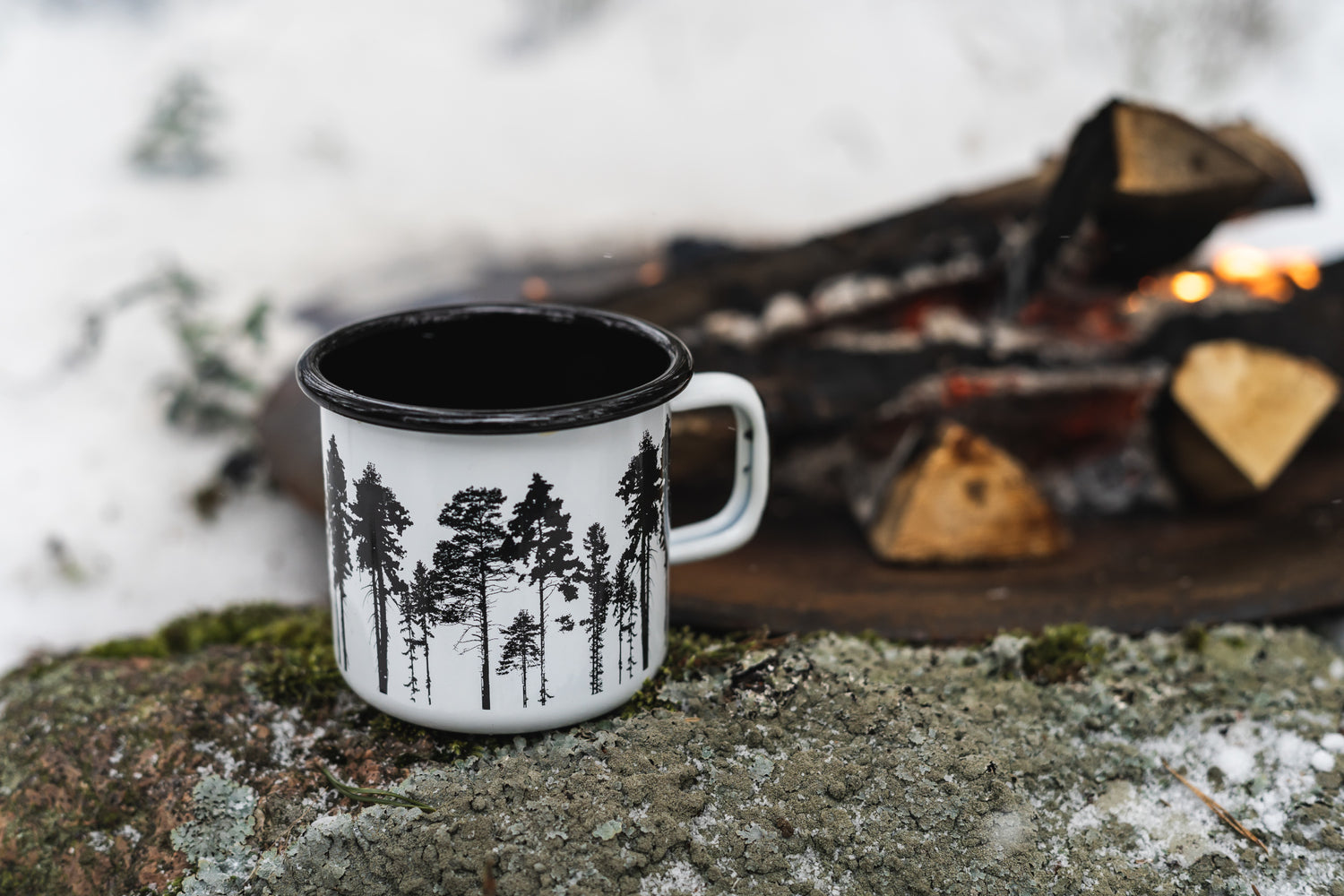 Emaille Tasse von Muurla mit Aufdruck von schwarzen Tannenbäumen, ein Feuer im Hintergrund